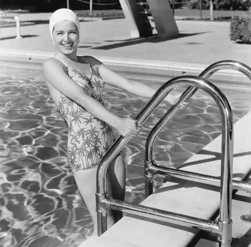 Woman standing on a pool ladder